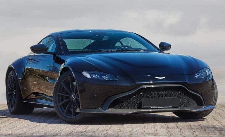 2024 Aston Martin parked on a scenic road with sleek design and modern features.
